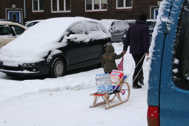 wintereinkauf familie schnee einkauf schlitten 